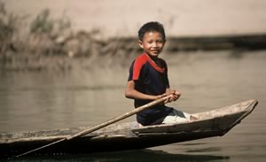 Southeast Asia Travel Laos  Boy in boat in Nam Ou river Smiling boy Fine Art Photography Copyright 2003 Brad Carlile photographer